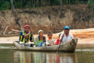 An indigenous family paddled down the upper Rupununi River in their dugout canoe. The Rupununi River is a major tributary of the Essequibo.